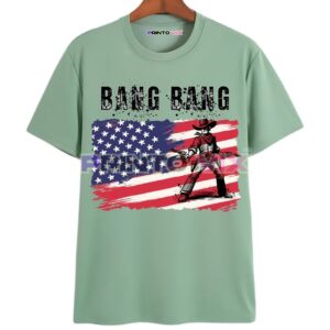 Mint green T-shirt featuring a distressed American flag background, bold BANG BANG text, and a cartoon cowboy holding pistols standing in front of the flag, www.Printovix.com